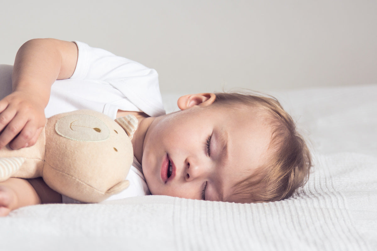 young boy sleeps with stuffed bear