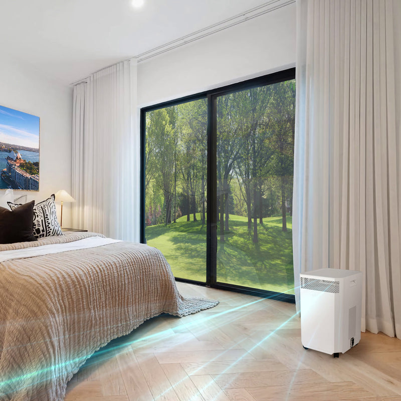 Load image into Gallery viewer, A modern bedroom with a grassy lawn and trees visible through a window. Inside, an INOVA air purifier quietly cleans the air, efficiently removing pet dander, dust, allergens and odours.