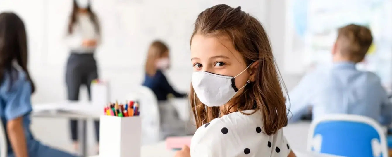 young girl wearing mask in classroom