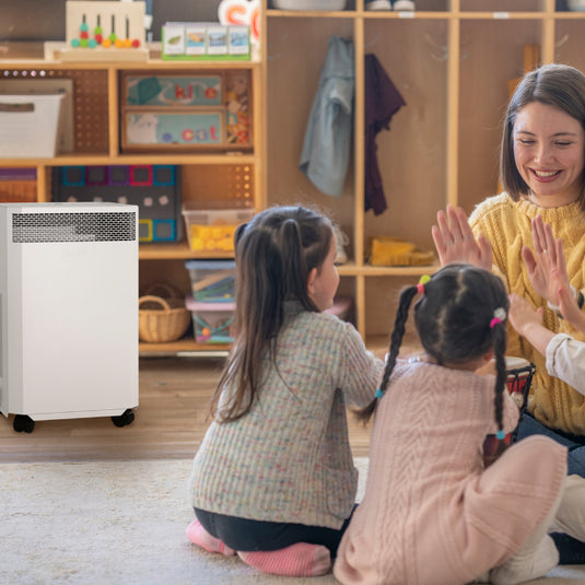 teacher plays with children near inova e8 air purifier