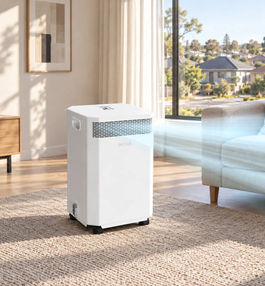 White air purifier with visible airflow on floor in modern living room with residential neighborhood view outside large window.