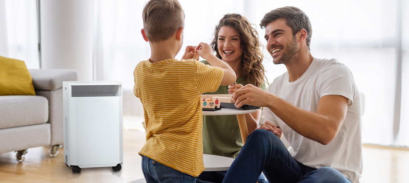 family playing on floor next to inova air purifier