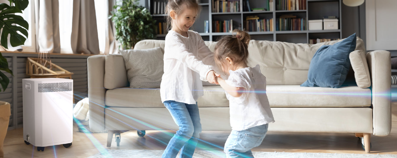 Two children playing in a living room with an air purifier.